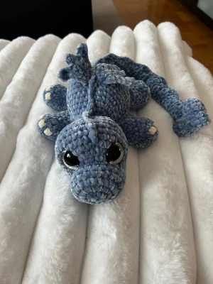 Blå/grå virkad drake🩵 - Denna söta drake letar efter sitt nya framtida hem🩵 Denna är virkad med kärlek, jag älskar att virka! Den är virkad av mjukt garn från Rusta, hårda ögon som inte går att ta av. Den är cirka 60cm lång om man sträcker ut svansen🐉