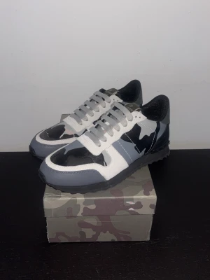 Valentino Rockrunners - Valentino rockrunners i vit, grå och svart. Storlek 43 kan passa 44. Mycket bra skick. Påse och dust bag följer med vid köp. Priset är lågt för att kvitto ej finns och dom blir inte sålda och vill helst bli av med dom. 