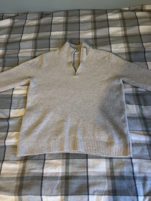 Beige tröja från A days march  - Mysig ljusgrå stickad tröja med halvzip och hög krage. Tröjan har långa ärmar och ribbade muddar vid ärmslut och nederkant. Perfekt för lager på lager och enkel att matcha till olika outfits. Passar om du är ca 175 cm lång