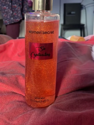 So Captivating Body Mist Women’secret - Glittrig body mist från Women’secret i doften So Captivating. Flaskan är genomskinlig med guldlock och innehållet är orange med skimrande glitter. Perfekt för dig som vill ha en fräsch och glittrande touch till din look.