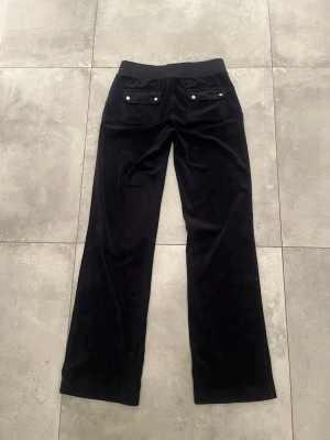 Mörkblåa Juicy Couture byxor  - Mörkblåa mjukisbyxor med bakfickor och silver detaljer, från Juicy Couture (nypris 1200kr)💕 Säljer för dem inte passar längre och inte kommer till användning. Byxorna är i bra skick, förutom att silver detaljerna på snörena har åkt av🩷 (Står ej för frakt och pris kan diskuteras) 