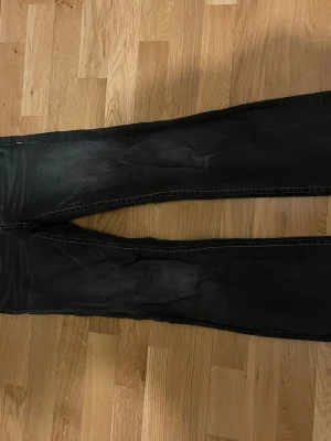 Mörkgråa lågmidjade bootcut jeans Gina - Snygga väldigt lågmidjade bootcut jeans i storlek 164 (passar mig som annars har storlek S). Använda väldigt lite pga har för många gråa jeans. Tråden har gått upp lite på fickan (se bild) men det är verkligen inget hål eller något man tänker på! Hör bara av dig om du har frågor! Skickar så fort jag kan.🥰