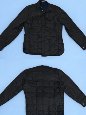 J.Lindeberg jacka - Stilren och mångsidig quiltad jacka från J.Lindeberg i klassiskt svart. Jackan har en lätt men värmande vaddering som gör den perfekt för vår, höst och milda vinterdagar. Designad med knappstängning framtill, två bröstfickor med lock samt diskreta sidfickor. Rak passform som funkar lika bra till vardags som till en mer uppklädd look. Hög kvalitet i material och sömnad, precis som man förväntar sig av J.Lindeberg. Hör av er om ni har några frågor // Oscar från global clothing.  Skick: mycket bra 