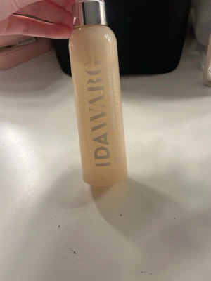 IDAWARG Vanilla Fudge Hair Mist - Säljer en IDAWARG Vanilla Fudge Hair Mist i en beige plastflaska med silverfärgat lock. Doften är söt och vaniljig, perfekt för att fräscha upp håret snabbt. Flaskan har en stilren design och är enkel att ta med i väskan. Produkt kvar till stecket jag ritat på baksidan.