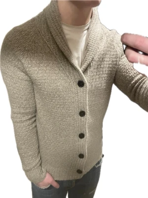 Beige stickad cardigan - Väldigt snygg beige stickad cardigan från Zara. Passar perfekt till kallare väder. Modellen är 180cm, 75kg. Priset kan såklart diskuteras!