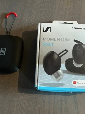 Sennheiser Momentum Sport - Hörlurar från Sennheiser som är i väldigt bra skick och fungerar fel fritt. Original box med alla delar finns med. Hörlurarna har funktion som kan mäta din puls samt din kroppstemperatur även har bra brus reducering och ljudkvalitet så perfekta för träningen och vardagligt bruk.