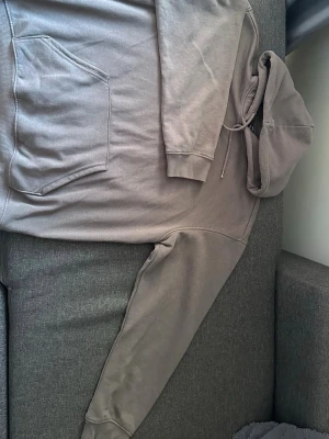 Beige oversized hoodie med ficka - Säljer en beige oversized hoodie med stor känguruficka framtill och justerbar huva med dragsko. Hoodien har ribbade muddar vid ärmslut och nederkant. Perfekt för en chill och avslappnad stil.