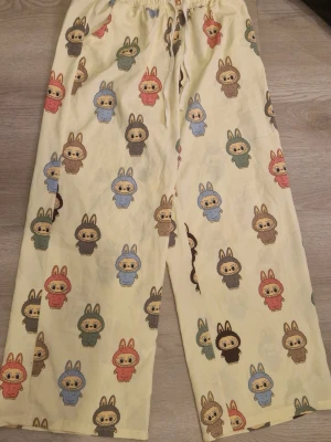 Gula pyjamasbyxor med labbobo mönster på! - Säljer ett par gula pyjamasbyxor/mjukisbyxor med olika labbobo på i flera färger som blått, rosa, grönt och brunt. Byxorna är också stretching i midjan. De står dock ingen storlek eller märke men dem passar mellan (cirka 155 till 163) har aldrig använt. Inga fläckar eller något som är sönder på dem 