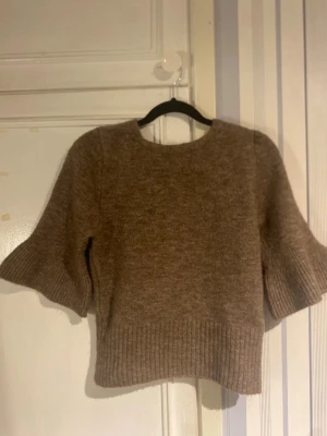 Stickad topp från Zara – storlek S - Mjuk och stilren stickad topp från Zara i varm brun/beige nyans. Kort ärm och ribbade detaljer som ger en smickrande passform. Det lilla extra är den öppna ryggen med knytband – enkel framtill, wow baktill 🤍 Perfekt både till jeans, kostymbyxor eller kjol. Funkar lika bra till vardag som uppklätt. Märke: Zara Storlek: S Skick: Mycket bra, sparsamt använd Färg: Brun/beige Detaljer: Öppen rygg med knyt, ribbad nederkant och ärmar Säljs då den tyvärr inte kommer till användning längre. Kan visa bil