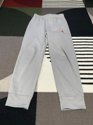 ✨ Jordan by Nike mjukisbyxor – Premium Kidswear ✨ - Stilrena och exklusiva Jordan by Nike mjukisbyxor i elegant ljusgrå färg. Tillverkade i mjukt och bekvämt material med en lyxig känsla – perfekta för både vardag och sportig stil.  Byxorna har en elastisk midja för optimal passform samt muddar vid bensluten som ger en modern och trendig look.   🔹 Storlek: 132–147 cm (10–12 år) 🔹 Märke: Jordan / Nike 🔹 helt ny och oandvänd 🔹 Skick: Mycket fint skick 🔹 Tillverkad i Vietnam (original)