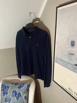 Mörkblå långärmad piké från Polo Ralph Lauren - Klassisk mörkblå långärmad pikétröja från Polo Ralph Lauren. Skick 9/10. Storlek M. Inga slitage. Skriv gärna om du har frågor.