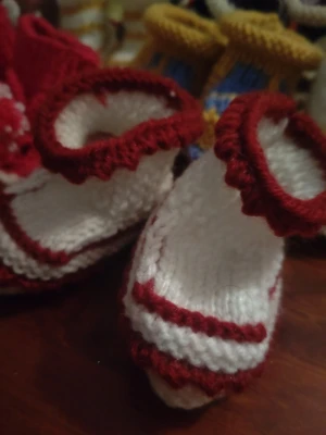 Handstickade vita tofflor med röd kant - Säljer ny handstickade tofflor för barn i vitt med röda detaljer och vågig kant. Perfekta för att mysa runt hemma. Mjukt garn och söt design som sticker ut.