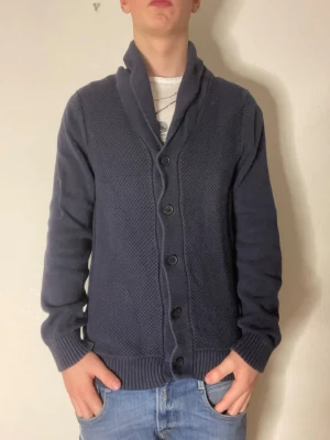 Mörkblå cardigan från selected homme - Tja jag säljer en mörkblå cardigan från Selected homme som är inprincip ny! Modellen på bilderna är 178 och väger cirka 70kg. Hör gärna av er vid funderingar eller frågor!
