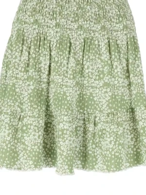 Grön blommig kortkjol med volang - Söt grön kortkjol med vitt blommönster och volang nertill. Kjolen har smock i midjan för en bekväm passform och är perfekt för varmare dagar. Lätt och luftig modell som ger en avslappnad och trendig look.