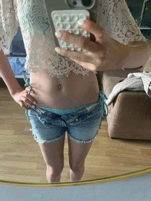 Blå jeansshorts med fjärilsbroderi - Säljer ett par ljusblå jeansshorts med fransig kant och snyggt fjärilsbroderi på ena bakfickan💕