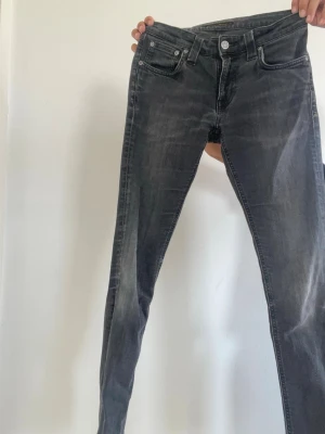 Svarta jeans från Nudie Jeans - Säljer dessa mörkgråa nudie jeans w26 l30. Om ni har frågor så är de bara att skriva och kan gå ner i pris vid snabb affär.