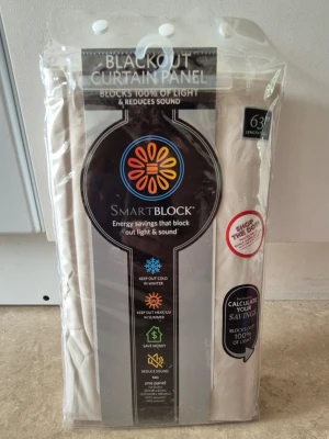 Mörkläggningsgardin - Säljer en beige mörkläggningsgardin från SmartBlock som blockerar 100% av ljuset och minskar ljud. Gardinen är 63 tum lång och har öljetter upptill för enkel upphängning. Perfekt för dig som vill ha det riktigt mörkt i rummet. Har testat en gång, den passade inte för mitt fönster. Så den är helt nytt.