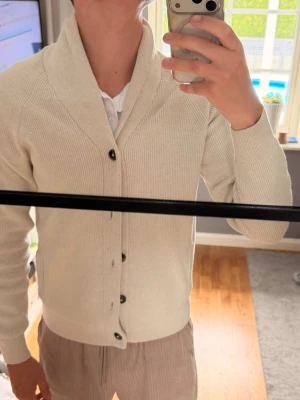 Beige kofta från M&S med sjalkrage - Säljer en stilren beige kofta från M&S i bomullsblandning. Koftan har fickor som ger en schysst touch.