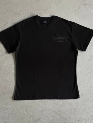Corteiz | Svart Tshirt  - Snygg svart t-shirt med ett diskret, ton-i-ton tryck både fram och bak. Klassisk rund hals och korta ärmar. Perfekt basplagg för en clean och stilren look.