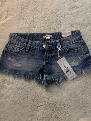 Blå denimshorts med fransig kant  - Säljer dessa lågmidjade jeansshorts från Gina 14+ shortsen är helt oanvända och helt nya. Skriv om ni undrar nått eller vill ha mer bilder!!💗💗