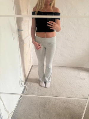 Svart offshoulder croppad topp - Snygg svart croppad topp med offshoulder-modell. Toppen har en tight passform och är perfekt för dig som gillar en stilren och enkel look. Materialet känns mjukt och stretchigt, vilket gör den bekväm att bära. Inga synliga loggor eller mönster.