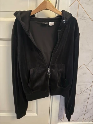 Svart ziphoodie med dragkedja - Mjuk och skön svart hoodie från Gina tricot med dragkedja framtill och två stora fickor. Klassisk huva med snörningshål och ribbade muddar vid ärmar och nederkant. Perfekt för en chill och avslappnad stil.