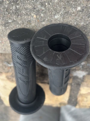Svarta handtag till cross eller cykel - Säljer ett par svarta handtag i gummi med greppvänlig yta och mönster. Passar till cross, moped eller cykelstyre. Handtagen har en bred kant i ena änden och är designade för bra grepp och kontroll. Märker ufo 