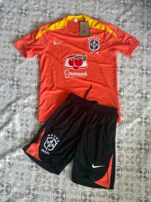 Brasilien träningsset Nike orange - Brasilien fotbollsträningsset i storlek S. Shortsen har fickor med dragkedjor. Helt nya och oanvända, Hör gärna av vid frågor!