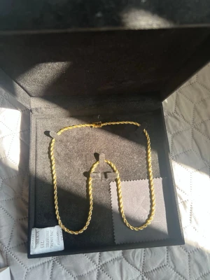 Guld plänterat 18k  - Säljer ett snyggt guldfärgat halsband från Karat Jewelry. Halsbandet har en tvinnad kedja som ger en exklusiv känsla och kommer i en elegant svart ask med gulddetaljer. Perfekt accessoar för dig som gillar stilrena smycken med lite extra bling.