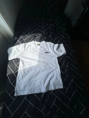 Vit premium T-shirt med stort ryggtryck – Strl L – Helt ny! - Säljer en stilren vit T-shirt i storlek L. Tröjan är helt ny och endast provad, så den är i nyskick utan fläckar, hål eller andra skador.  Den har en minimalistisk design med ett mindre svart tryck på vänster bröst och ett större matchande tryck på ryggen, vilket ger en snygg och modern look. Tillverkad i 100 % bomull, vilket gör den mjuk, bekväm och skön att bära. Tillverkad i Turkiet enligt tvättlappen. Går att diskutera    * ✅ Storlek: L * ✅ Skick: Helt ny, endast testad * ✅ Material:100% bom