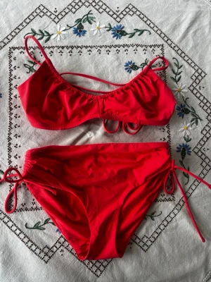 Korall  bikini med knyt och höga trosor - Jättefin bikini från Lindex, oanvänd men ingen prislapp kvar. På bilderna ser den röd ut men är korall färgad i verkligheten 