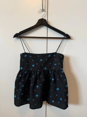 Blommig peplumtopp - Supersöt svart topp med blåa blommor från Envii. Säljer då den tyvärr är för liten för mig. Priset går att diskutera! Ta dock gärna hänsyn till nypriset runt 700kr och att den knappt är använd🥰