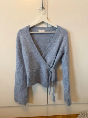 Ljusblå omlottkofta - En blå stickad omlottskofta från Gina Tricot. Den är köpt i somras men har endast använts enstaka gånger, då jag inte riktigt kände att det var min färg. Annars är den superfin.  Tröjan är i storlek M men tycker den passar mig jättebra som vanligtvis brukar ha S. Den har inga tecken på användning och har inte upptäckt några defekter. Nypris 399kr💕