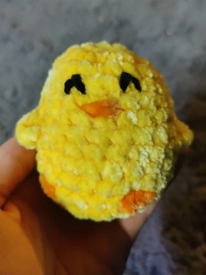 Gul mjukisdjur kyckling - Söt liten mjukisdjur i form av en kyckling. Den är gul med orange näbb och fötter, samt svarta broderade ögon. Tillverkad i mjukt, fluffigt garn och har små vingar på sidorna. Perfekt som dekoration eller leksak.