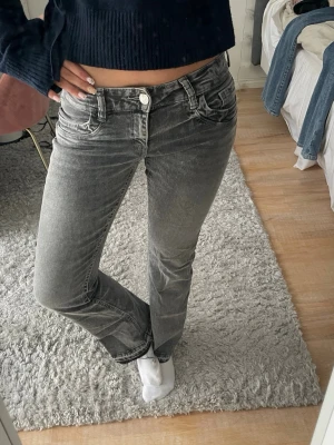Low waist grå bootcut jeans Gina Tricot - Säljer ett par jättefina grå urtvättade bootcut jeans från Gina Tricot i storleken 164/Xs, passar mig som är 167cm🌸 jätte fint skick nästan aldrig använda. Har sprättat längst ner på jeansen vilket gör att de är längre. Säljer pågrund av att de ej kommer till användning☺️