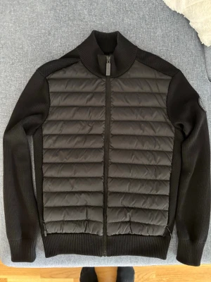 Canada Goose HyBridge Knit jacket - En skön stickad cardigan från Canada Goose som är Black Label. Storlek S från Canada Goose sitter bra på mig som är 176 cm och smal kroppsbyggnad. Skriv om ni har frågor!