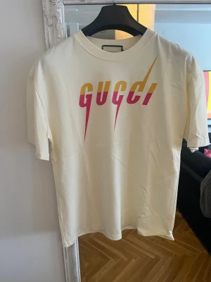 Cream white  t-shirt med färgglad logga - Oversized. Small osar som medium. 