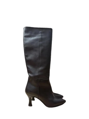 Svarta knähöga läderstövlar Rachel Marvi  - Säljer ett par svarta knähöga stövlar i äkta läder med smal, spetsig tå och elegant smal klack. Köpta i Italien från ett italienskt märke Rachel Marví. Super bekväma och använda ett par gången. Finns litet slitage på klacken 