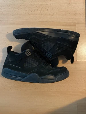 Jordan 4 black cat (2020) - Ett par Jordan 4 black cat som jag har använt några gånger. De är ganska smutsiga men enkla att tvätta. Skriv för mer information.