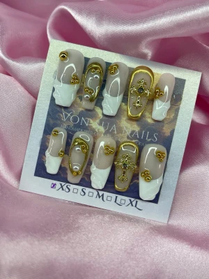 GoldenSaint (XS);Medium Coffin - Snygga handgjorda press-on naglar i nude och vitt med fransk tipp och 3D gulddetaljer som kors och ornament. Naglarna har en medium längd, kistformad design och glänsande finish. Perfekt för dig som vill ha en unik och lyxig look.XS: 14 mm, 11 mm, 11,5 mm, 10 mm, 8 mm 
