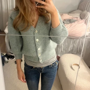Grå/grön stickad kofta med knappar - Grön/grå stickad kofta från Lindex. Jätte skön och fin att ha till vardag men passar även till finare tillfällen. Pris kan diskuteras! 