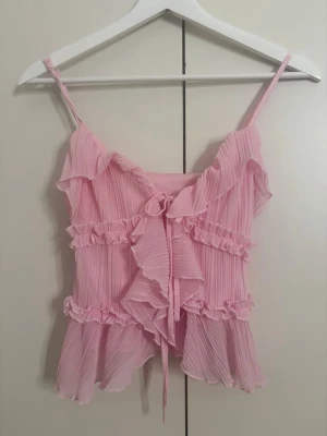 Sötaste rosa toppen🎀 - Säljer denna drömiga topp från Amisu. Toppen har fina volanger, plisserat tyg och en söt knytning framtill. FÄRG: Ljusrosa/Bubblegum pink🌸 STORLEK: XS💞 Men passar mig som är S-M MÄRKE: Amisu (New Yorker)❤️ SKICK: Helt ny använt 0ggr bara testat!🎀 FRAKT: Jag postar samma eller nästa dag!📦🤍 Vid frågor skriv gärna till mig🥰