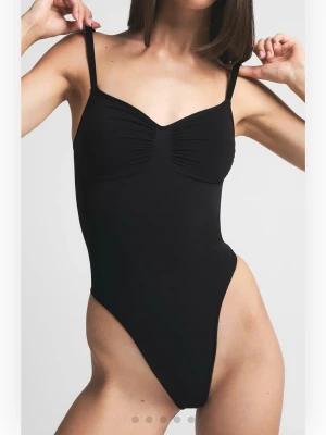 SKIMS thong bodysuit - Skims body suit i färgen onyx (svart), i storlek xxs. Perfekt för en snatched look! Har ej testat på då jag såg direkt att jag beställt en alldeles för liten, men har inte kunnat skicka tillbaka. I nytt skick!