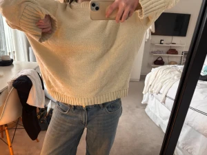 Oversized off white stickad tröja - Mysig oversized stickad tröja i off white med breda ribbade muddar vid ärmslut och nederkant. Tröjan har en rak passform och rund halsringning. Perfekt för lager på lager och chill stil.