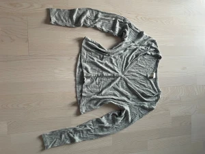 Långärmad topp - Lite ribbad tröja / kofta med v-ringning. Knappar. Stretchigt material. 