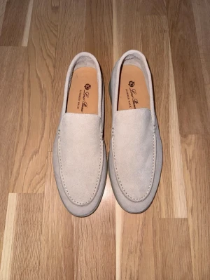 Loro Piana Loafers  - Säljer ett par stilrena loafers i ljus beige mocka. Väldigt lite använda och i toppskick. Klassisk modell som passar både till kostym, chinos och jeans. Mjuk och bekväm sula – perfekta för vår/sommar eller som clean vardagssko.