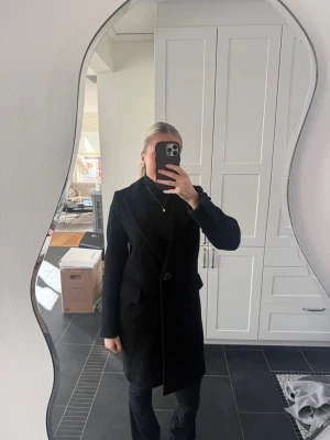 Lång kappa🤍 - Säljer denna långa kappan från Zara i jättefint skick då den inte används🤍 Den har slit på baksidan och två fickor på framsidan.