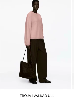 Stickad tröja i valkad ull - Säljer en stilren stickad tröja i valkad ull med rund hals och långa ärmar. Jag säljer den i ljusrosa men visar den mörkgrå färg för att visa hur den passformen är. Right vid midja men med lite piffigare armar. 100% ull. Helt ny, var för liten för mig. 