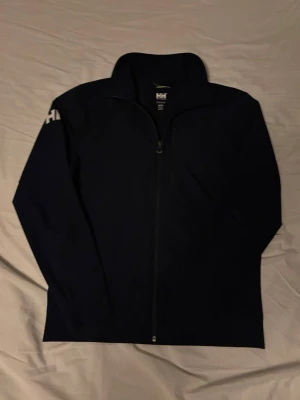 Helly Hansen Cardigan - Hej, säljer en Helly Hansen cardigan i en tunt stretchigt material som är väldigt bekvämt, hör av dig vid fler funderingar!