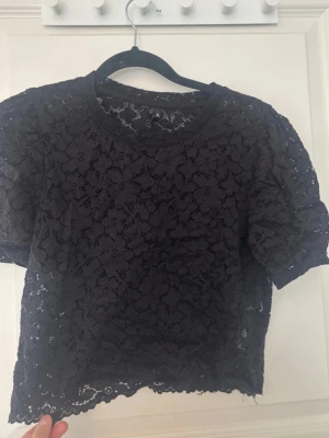 Spetstopp - Spetstopp med puffiga ärmar, spetsmönster är med blommor